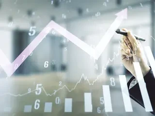 Das Bild zeigt eine Hand mit Stift die an einem virtuellem Finanzdiagramm arbeitet
