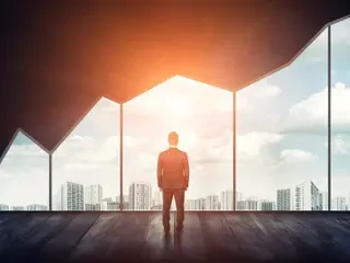 Mann steht im Büro blickt auf Skyline